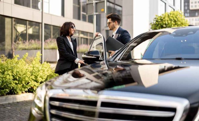 female-chauffeur-helps-businessman-with-laptop-get-out-car-opening-door-concept-personal-driver-luxury-taxi-business-trips (1)